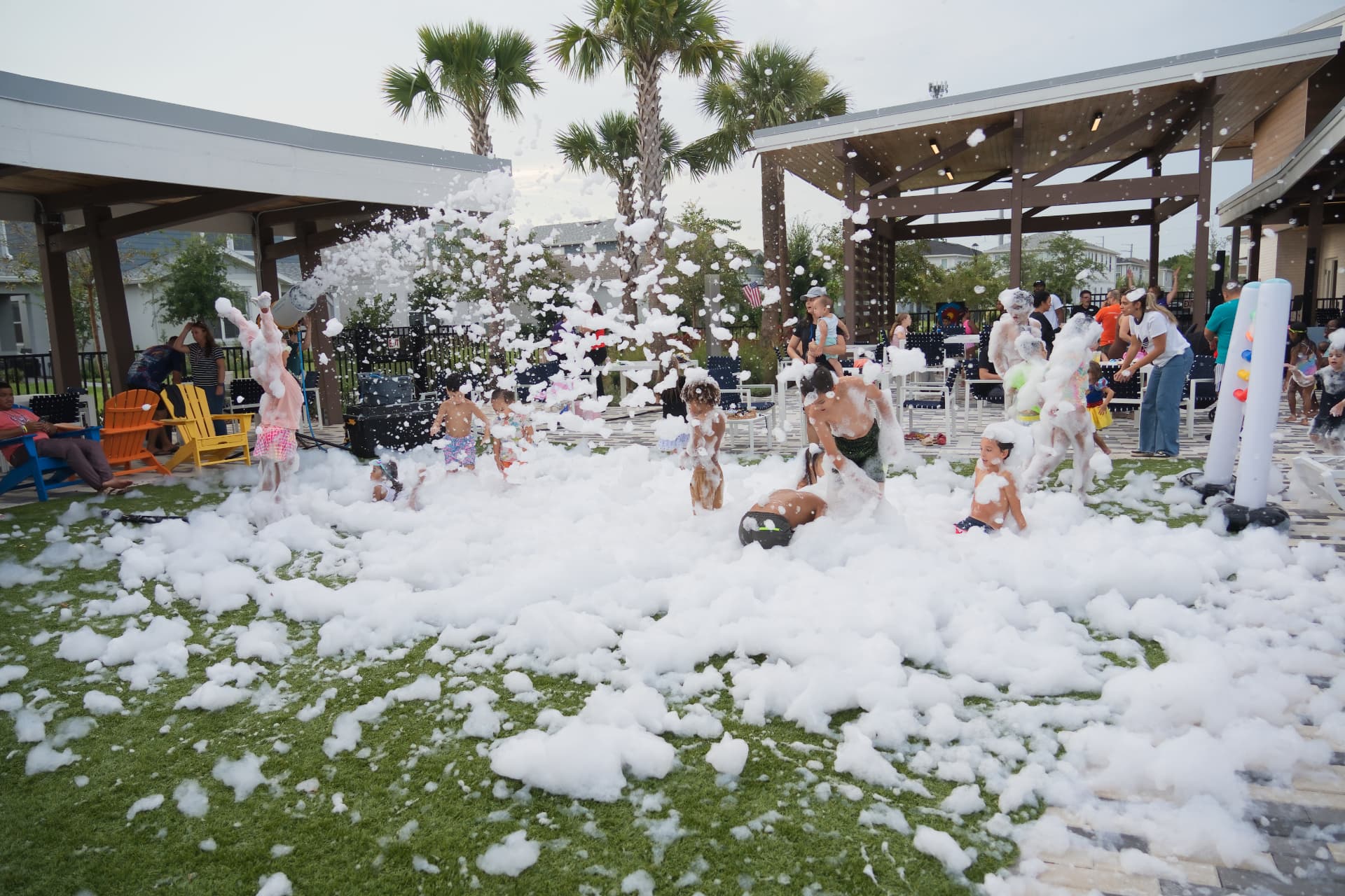 Wide shot of a finished foam zone covering a lawn with parents seated on the perimeter watching kids play