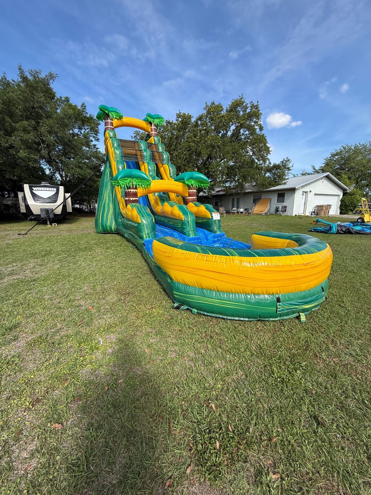 Side profile of an inflatable water slide setup at a school event.